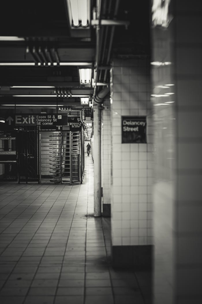 service-03 A moody black and white view of Delancey Street subway station in NYC, emphasizing urban architecture.